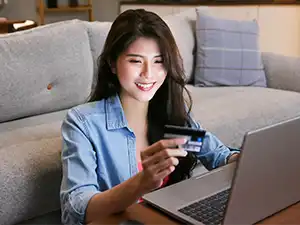 Woman online shopping at home holding credit card