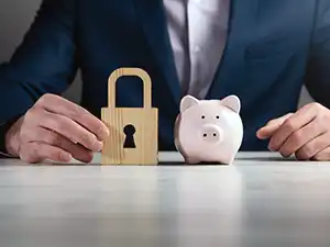 Business man holding security lock next to piggy bank